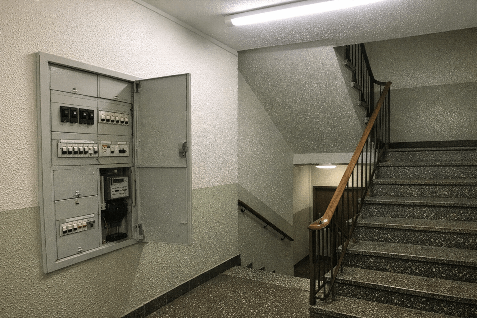 Gepflegtes Treppenhaus in älterem Mehrfamilienhaus mit Sicherungskasten für Elektriker-Notdienst